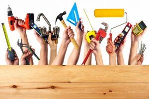 Hands with construction tools. House renovation background.