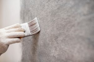 hand of worker use brush for color paint concrete Loft style on Les enduits décoratifs, de nouveau plébiscité par les clients