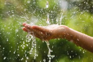 Close-up of wet female hands and clear water splashes
