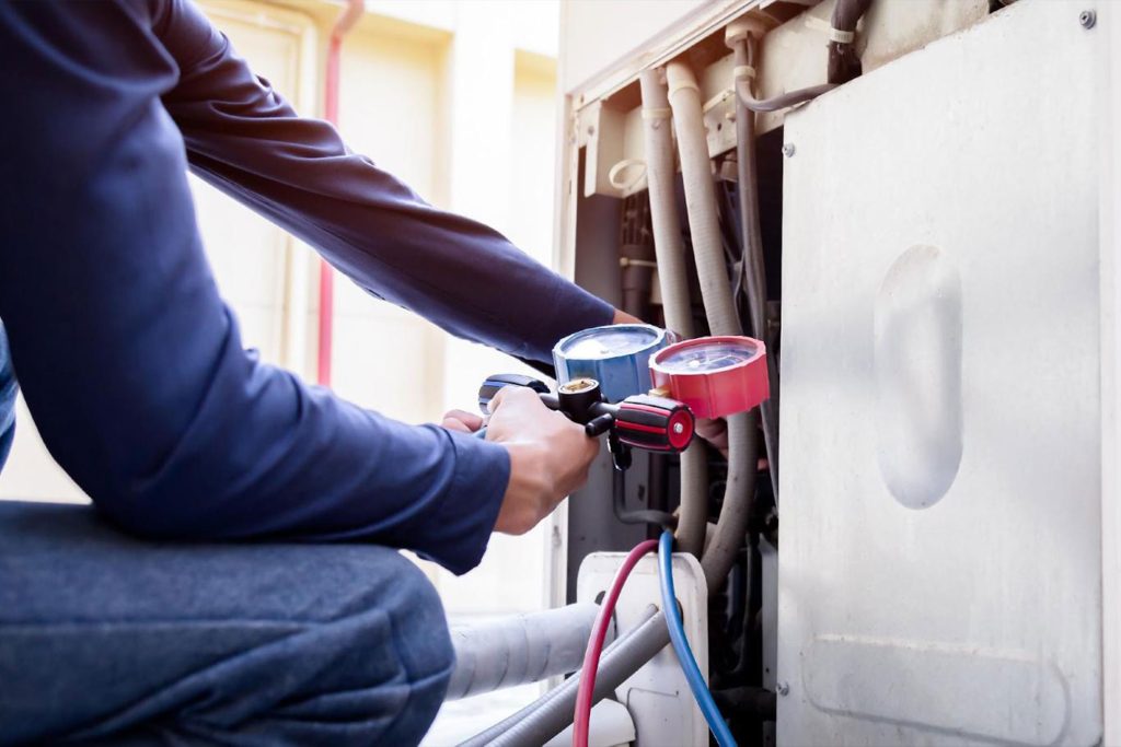 Chauffagiste effectuant une opération de maintenance sur une pompe à chaleur
