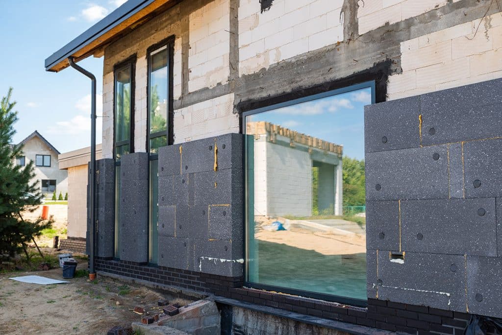 Professionnel du bâtiment expliquant un devis de rénovation globale à ses clients.