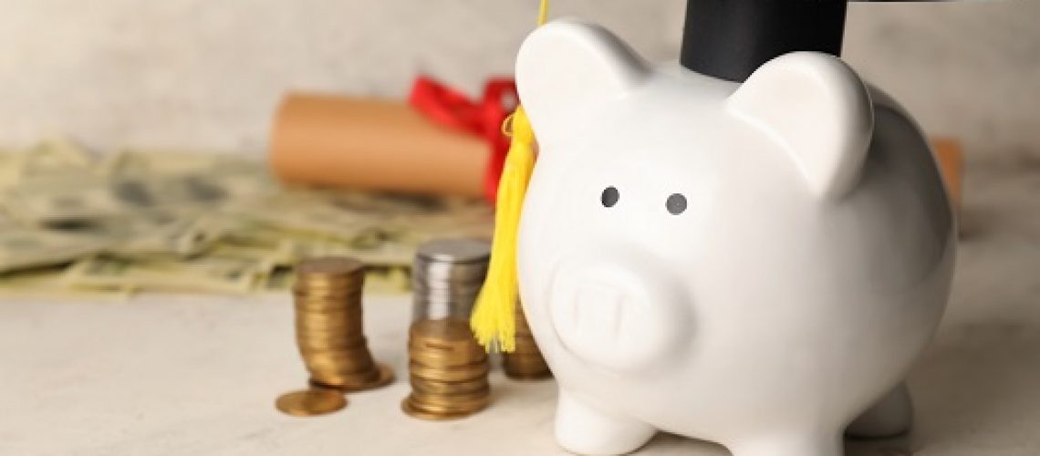 Piggy bank with graduation hat and coins on light background