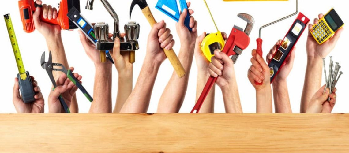 Hands with construction tools. House renovation background.