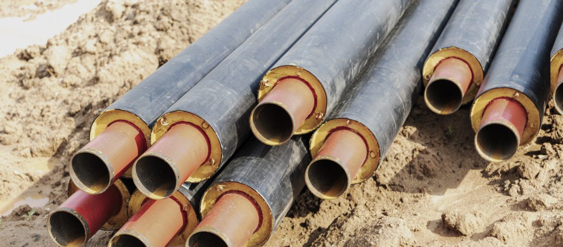 Laying heating pipes in a trench at construction site. Energy efficient insulated pipes. Cold and hot water, heating and heating system of apartments in the house. Renouvellement obligatoire de votre AIPR - Autorisation à Intervenir à Proximité des Réseaux en 2023
